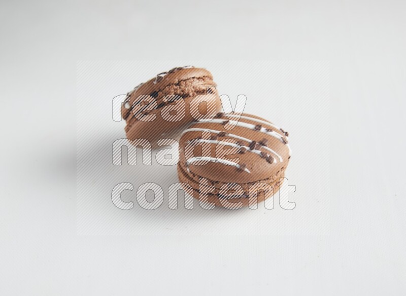 45º Shot of two Brown white Chocolate Caramel macarons on white background