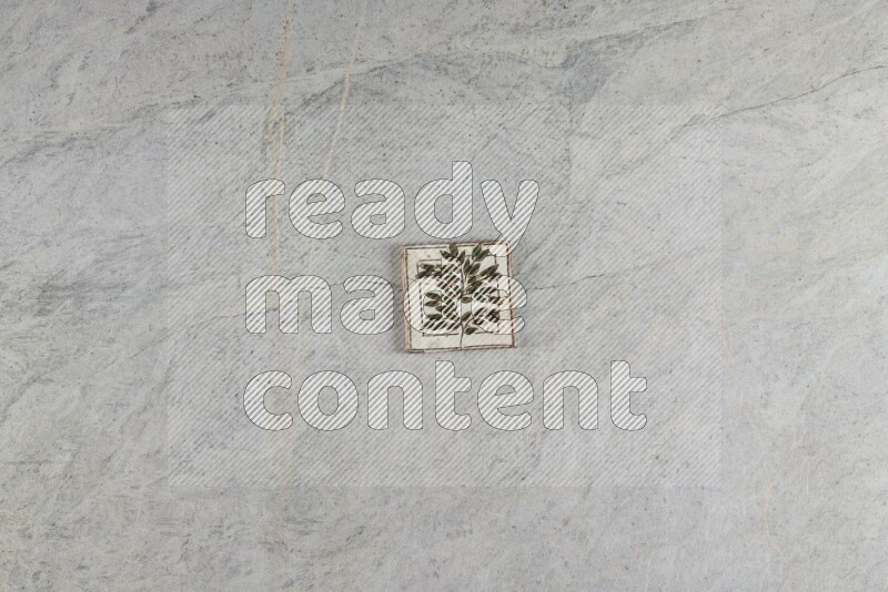 A decorative pottery coaster on grey marble background
