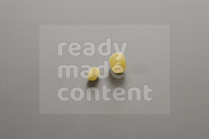 Small rings pasta with other types of pasta on grey background