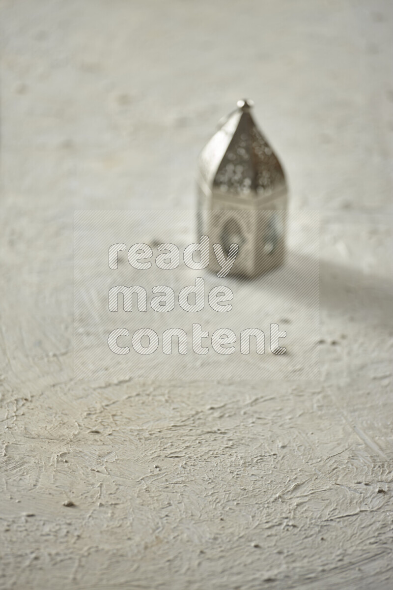 A lantern placed on a textured white background