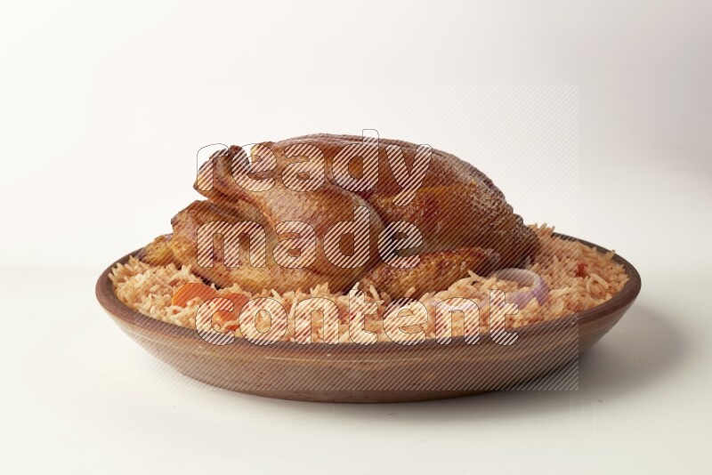 red basmati Rice with whole roasted chicken on a pottery plate direct on white background