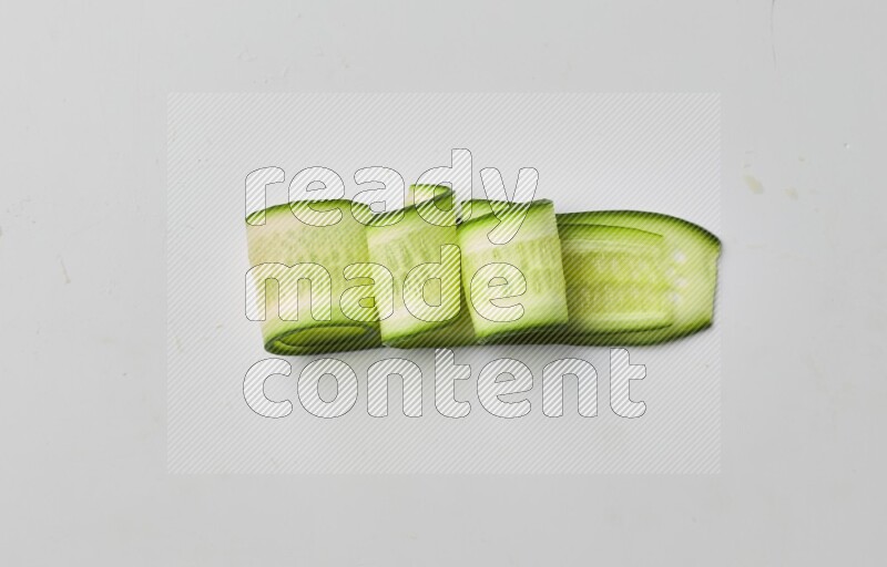 Three cucumber ribbons on a white background