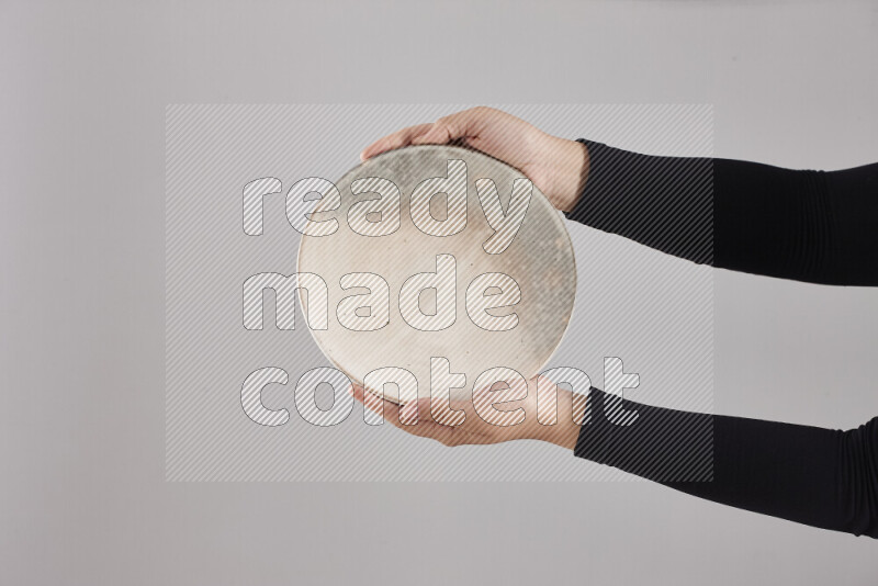 A woman in black abaya holding different pottery essentials in different positions