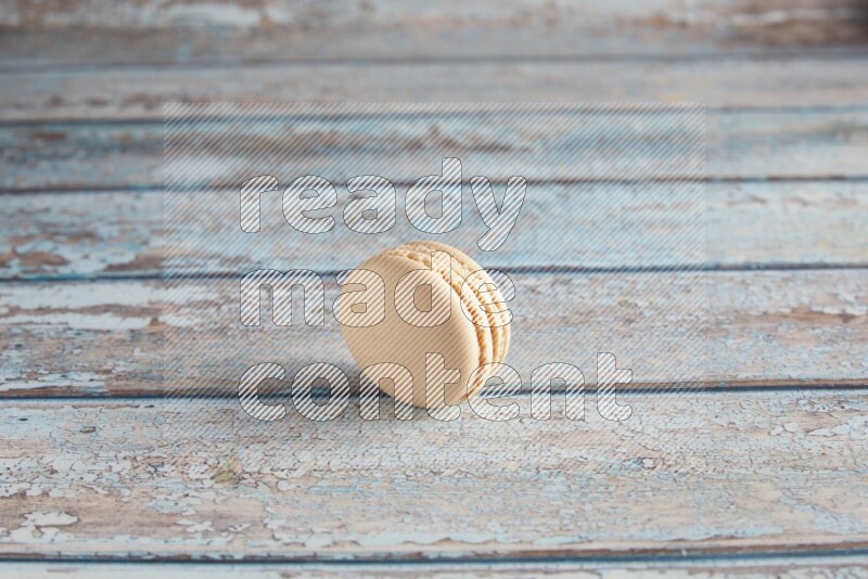 45º Shot of White Caramel fleur de sel macaron on light blue wooden background
