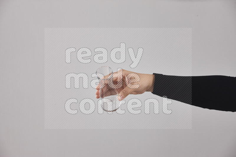 A woman in black abaya holding different glassware in different positions