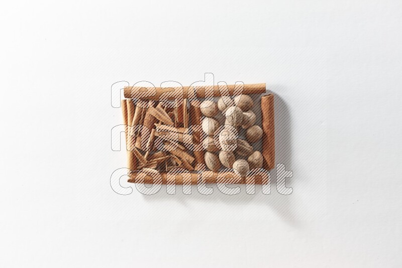 2 squares of cinnamon sticks full of cinnamon and nutmeg on white flooring
