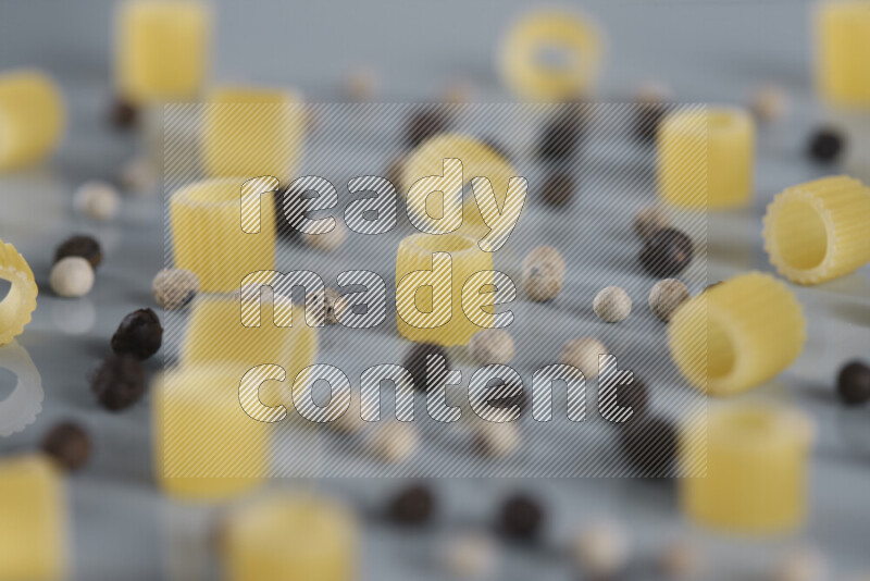 معكرونة مع مكونات متنوعة من الطماطم والثوم والبصل والفلفل الأحمر والفلفل الأسود والفلفل الأبيض وأوراق الغار وإكليل الجبل والهيل و مشروم على خلفية زرقاء فاتحة