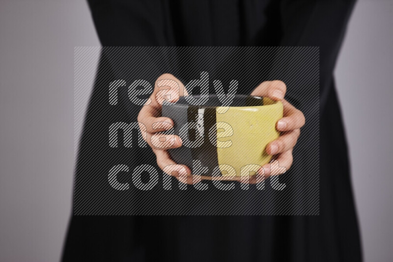 A woman in black abaya holding different pottery essentials in different positions
