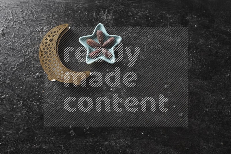 Dates in pottery bowl with a wooden lantern in a dark setup