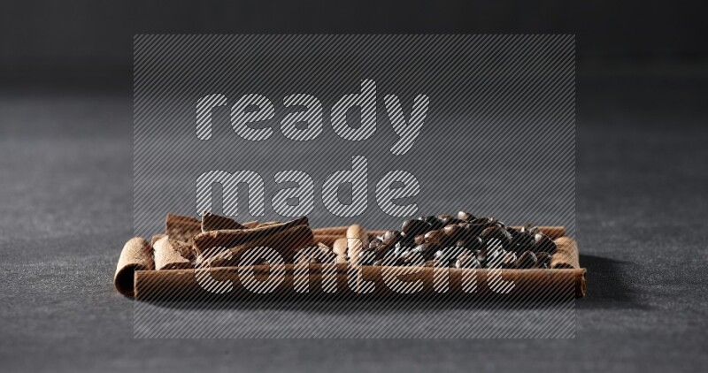 2 squares of cinnamon sticks full of coffee beans and cinnamon on black flooring