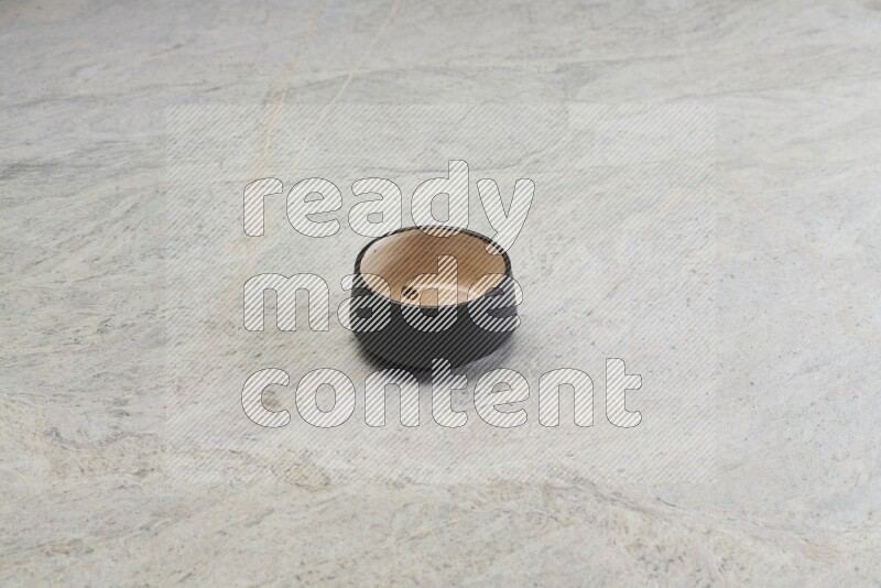 A black pottery bowl on grey marble background