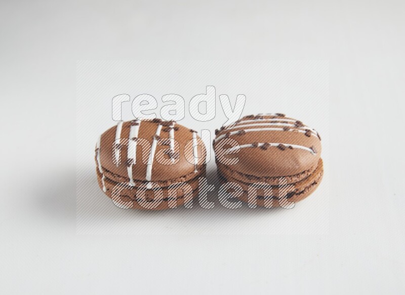45º Shot of two Brown white Chocolate Caramel macarons on white background