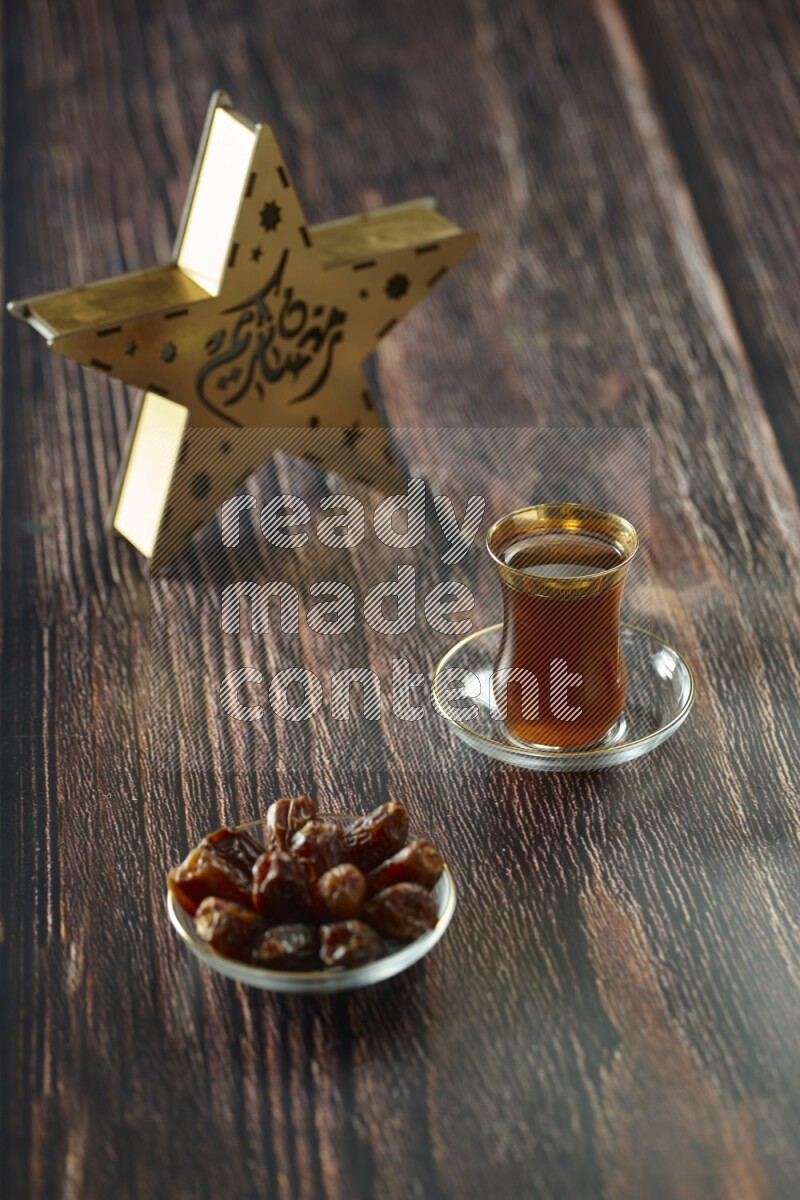 A wooden golden star lantern with different drinks, dates, nuts, prayer beads and quran on brown wooden background