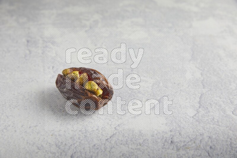 pistachio stuffed madjoul date on a light grey background
