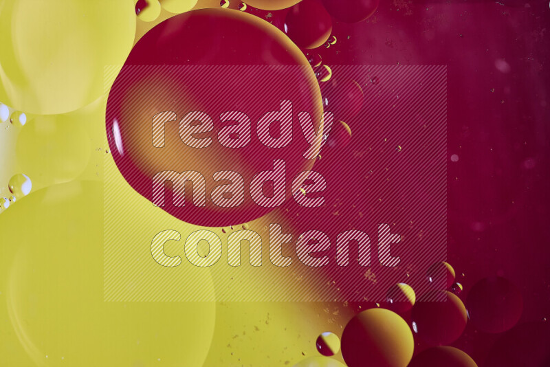 Close-ups of abstract oil bubbles on water surface in shades of yellow and pink