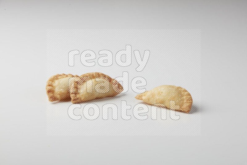 Three fried sambosas on a white background