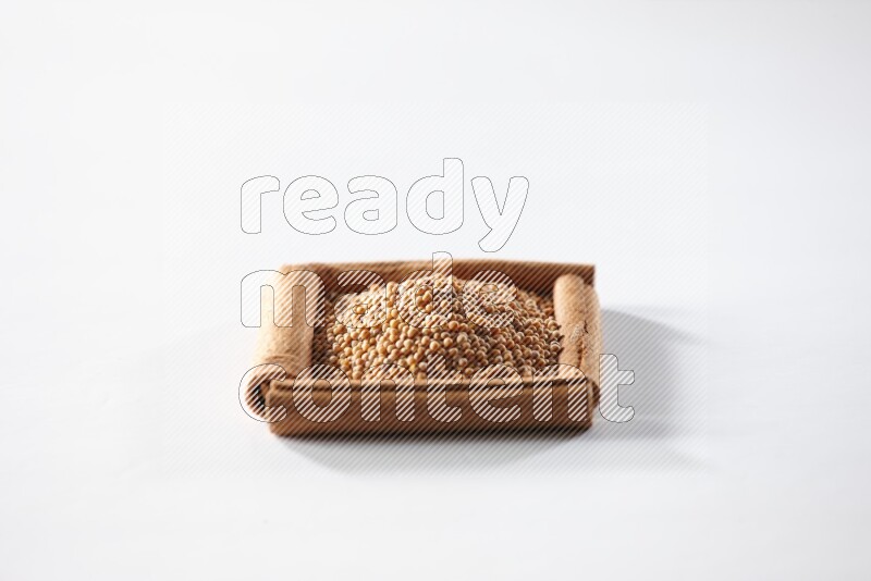 A single square of cinnamon sticks full of mustard seeds on white flooring