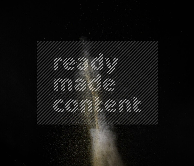 A side view of brown powder explosion on black background
