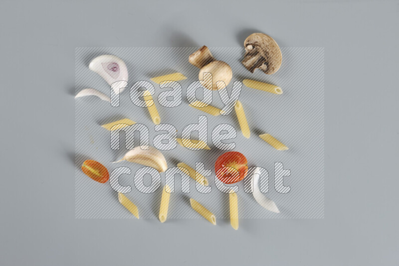 معكرونة مع مكونات متنوعة من الطماطم والثوم والبصل والفلفل الأحمر والفلفل الأسود والفلفل الأبيض وأوراق الغار وإكليل الجبل والهيل و مشروم على خلفية زرقاء فاتحة