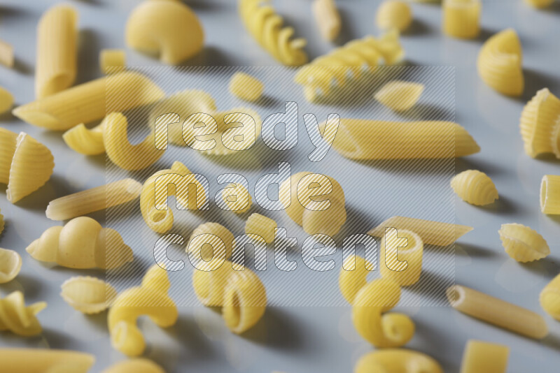 Different pasta types on light blue background