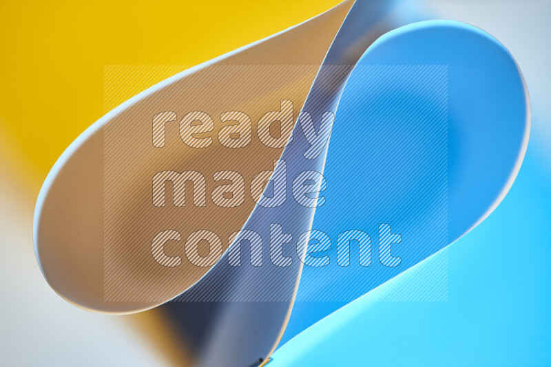 An abstract art of paper folded into smooth curves in blue and yellow gradients