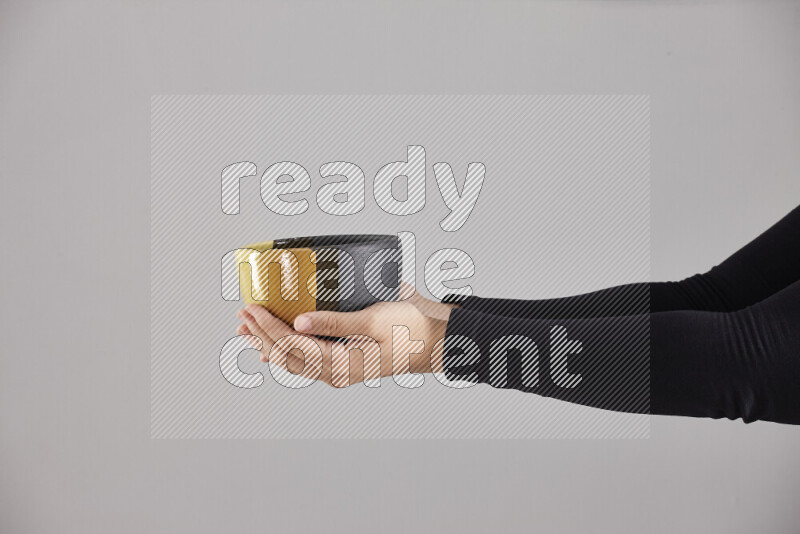 A woman in black abaya holding different pottery essentials in different positions