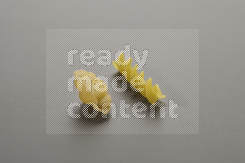 Snails pasta with other types of pasta on grey background