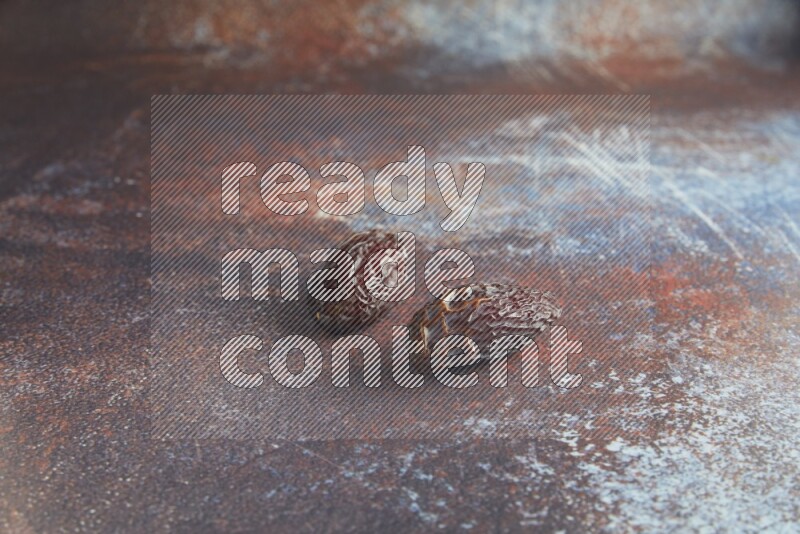two madjoul dates on a rustic reddish background