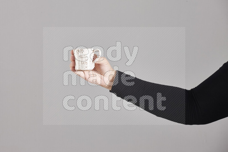 A woman in black abaya holding different pottery essentials in different positions