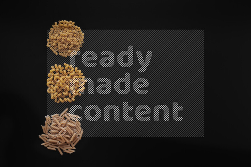 Different pasta types in 3 bunches on black background