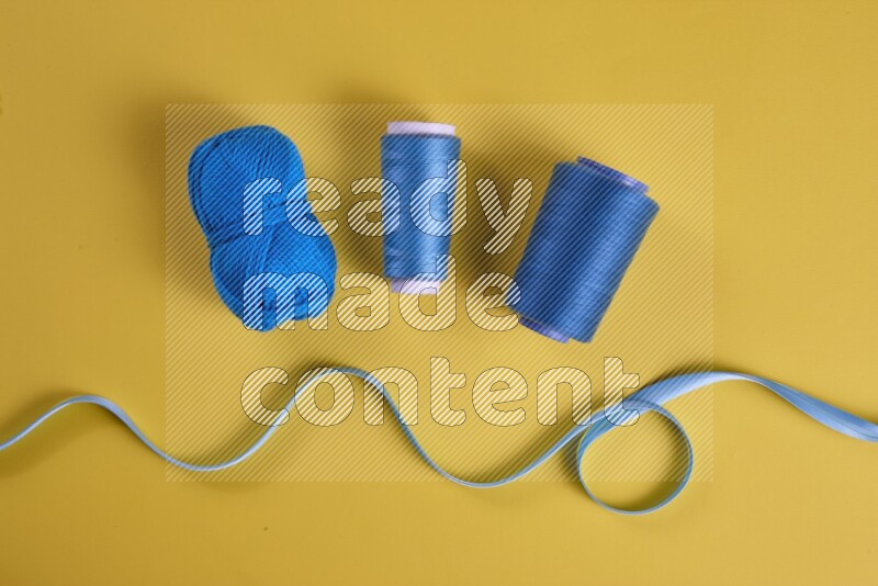 A blue collection of sewing and tailoring tools arranged on a yellow background