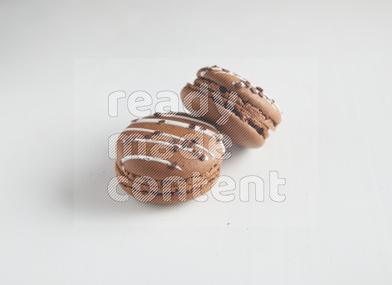 45º Shot of two Brown white Chocolate Caramel macarons on white background