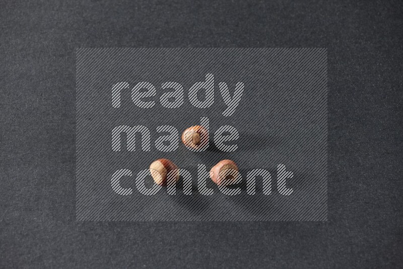 3 hazelnuts on a black background in different angles