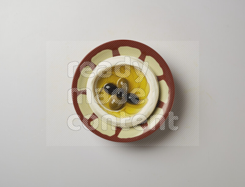 Lebnah garnished with olives in a traditional plate on a white background
