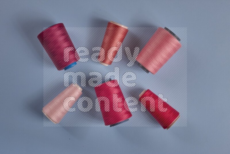 A pink collection of sewing and tailoring tools arranged on a blue background