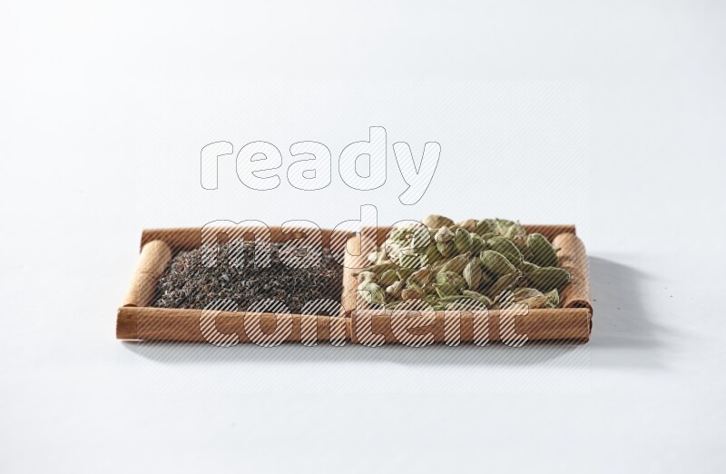 2 squares of cinnamon sticks full of black tea and cardamom on white flooring