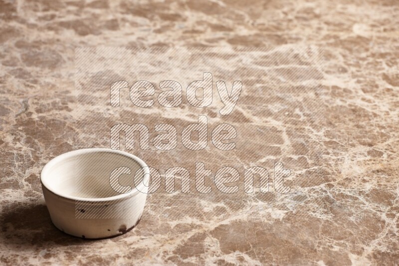 A white pottery bowl on beige marble background