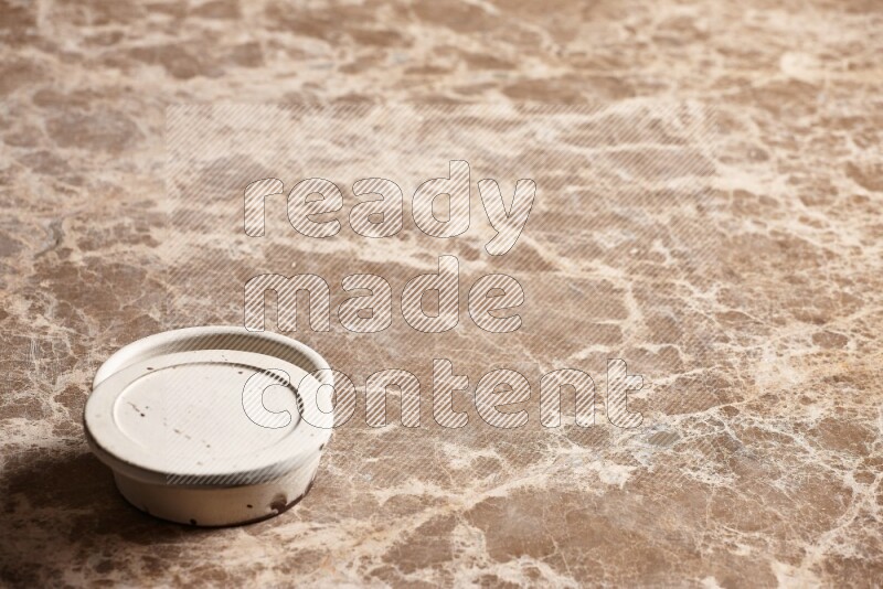 A white pottery bowl on beige marble background