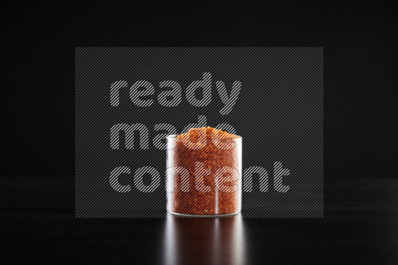 Lentils in a glass jar on black background