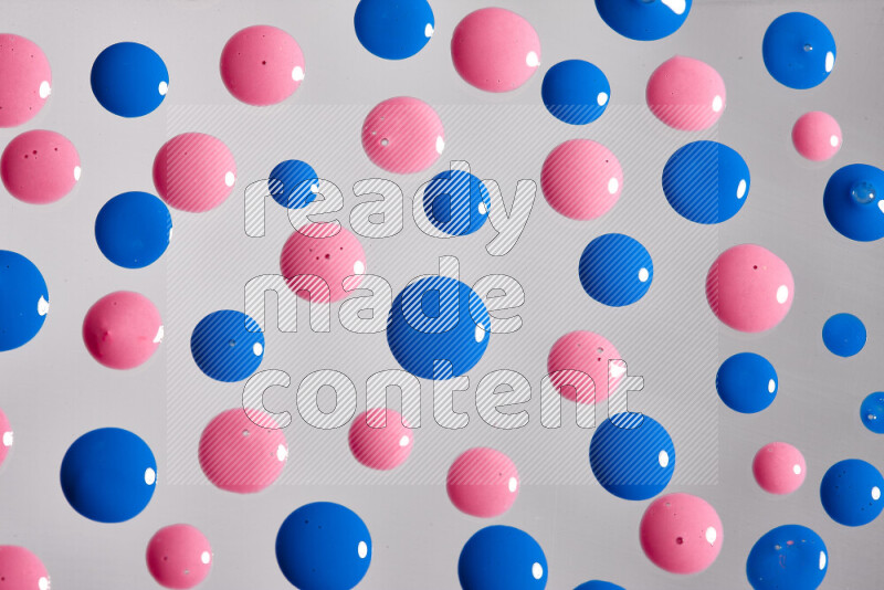 Close-ups of abstract pink and blue paint droplets on the surface