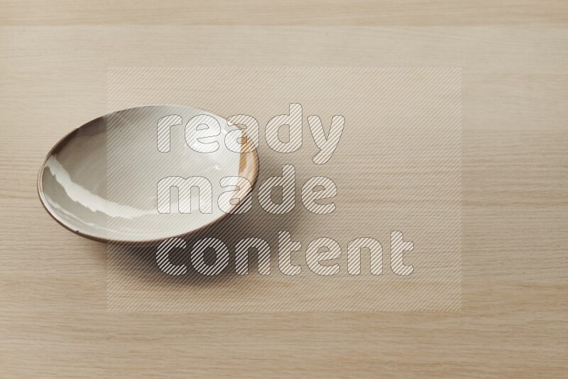 A multicolored pottery plate on light wooden background