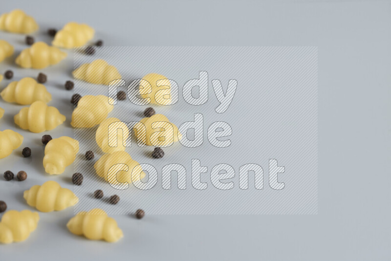 معكرونة مع مكونات متنوعة من الطماطم والثوم والبصل والفلفل الأحمر والفلفل الأسود والفلفل الأبيض وأوراق الغار وإكليل الجبل والهيل و مشروم على خلفية زرقاء فاتحة