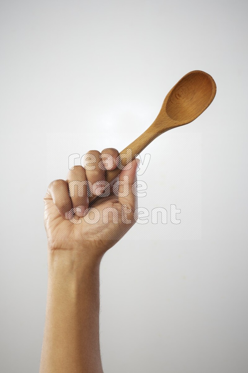 Male Hand Holding Wooden spoon on white background