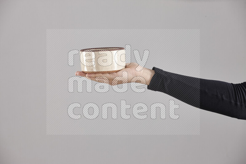 A woman in black abaya holding different pottery essentials in different positions