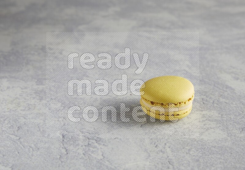 45º Shot of Yellow Lime macaron on white marble