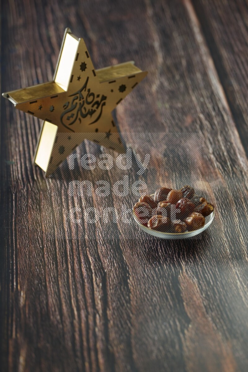 A wooden golden star lantern with different drinks, dates, nuts, prayer beads and quran on brown wooden background