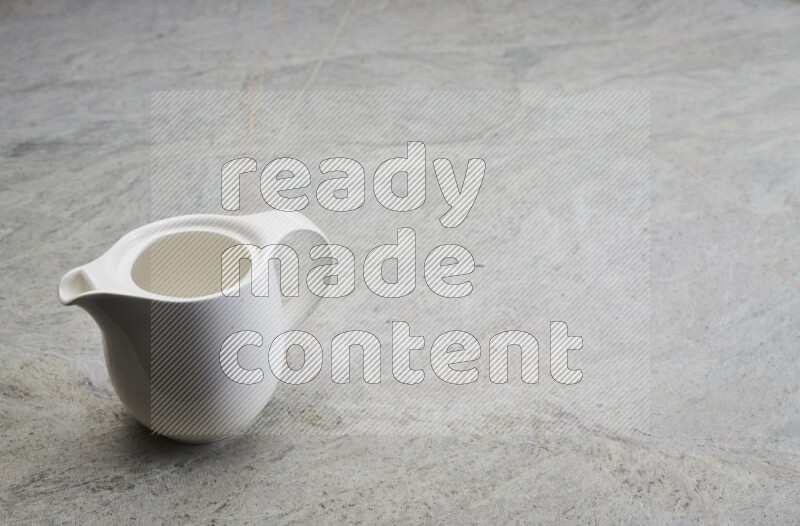 A ceramic milk jug on grey marble background
