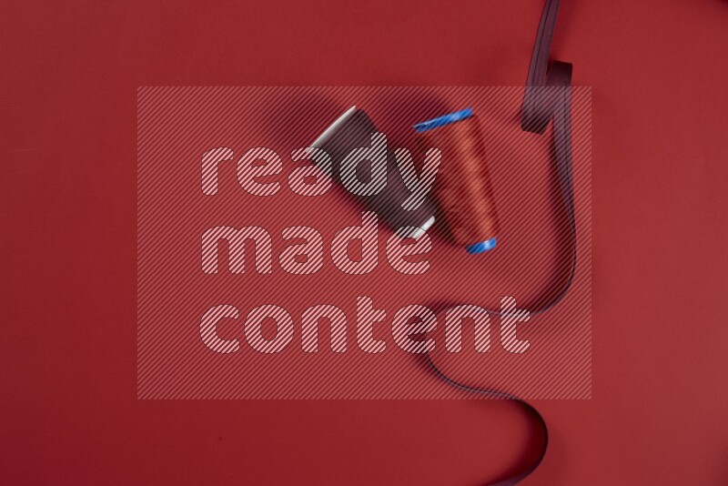 A red collection of sewing and tailoring tools arranged on a red background