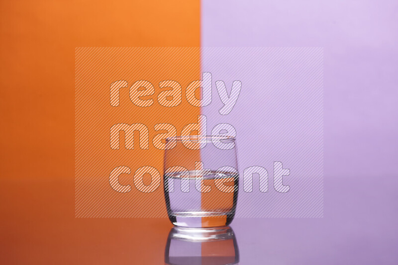 The image features a clear glassware filled with water, set against orange and light purple background