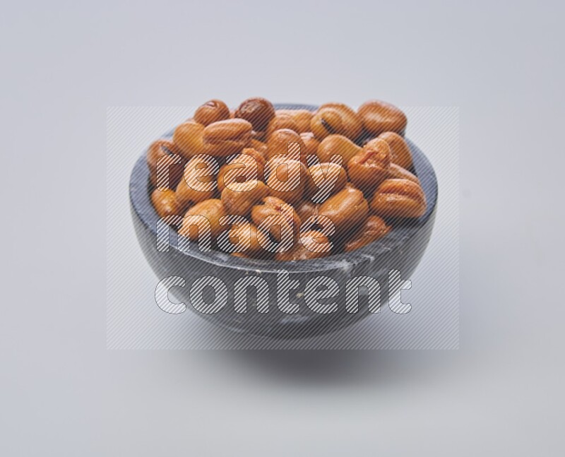 Close up shot of cooked fava beans (foul) in a container on white background